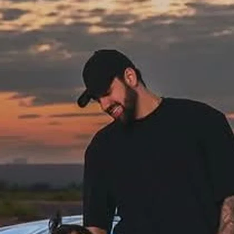Foto de perfil de Leonardo Vieira, de boné preto, ao pôr do sol